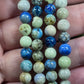 Azurite, hackmanite and chrysocolla crystal/mineral beaded bracelet being held on 4 fingers to represent size