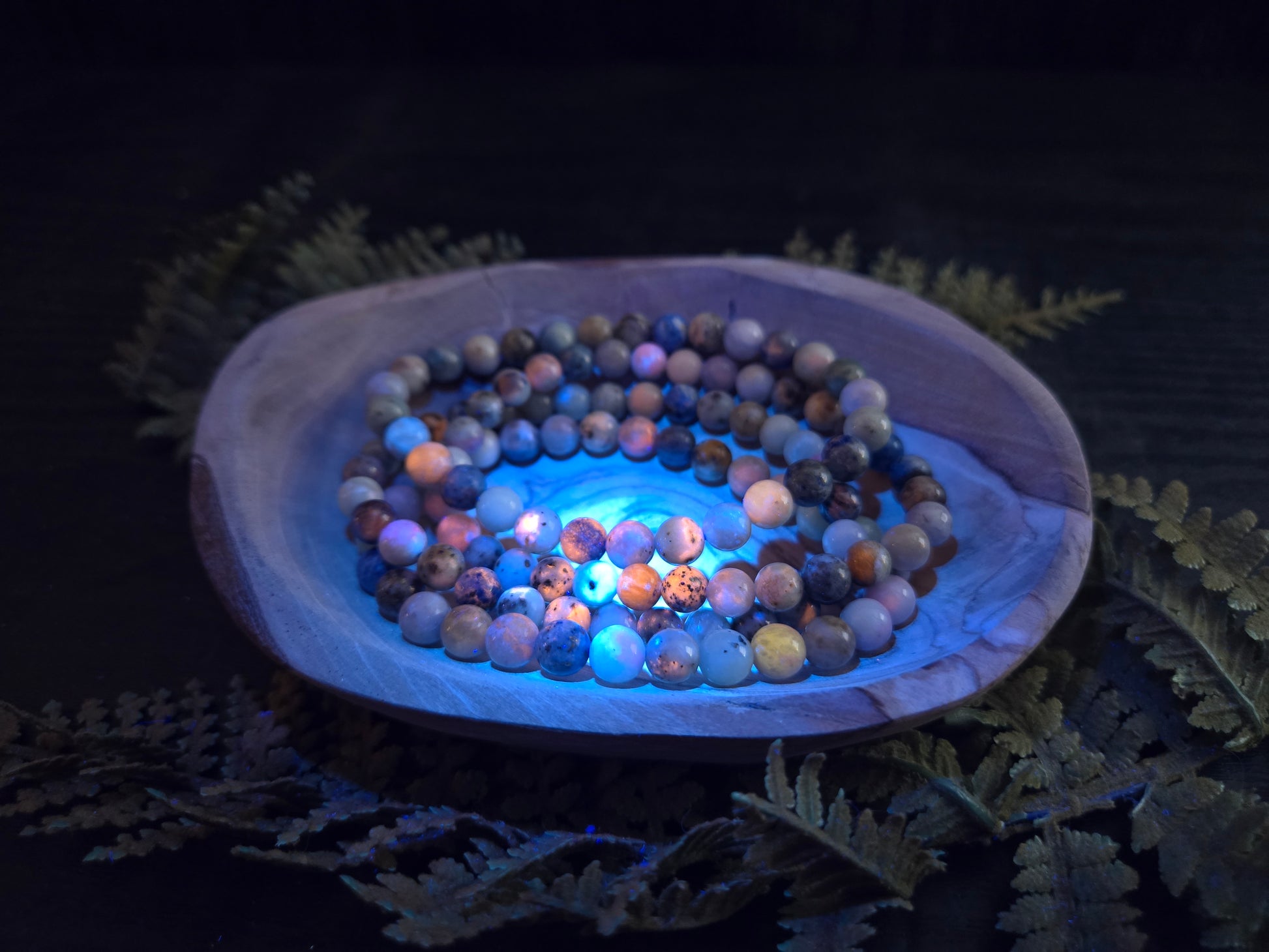 Azurite, hackmanite and chrysocolla crystal/mineral beaded bracelet under UV light to show the orange reactivity