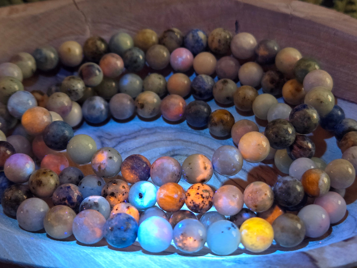 Azurite, hackmanite and chrysocolla crystal/mineral beaded bracelet under UV light to show the orange reactivity