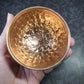 Hand holding a copper bowl with textured surface against a dark background - Dark Star Curiosities